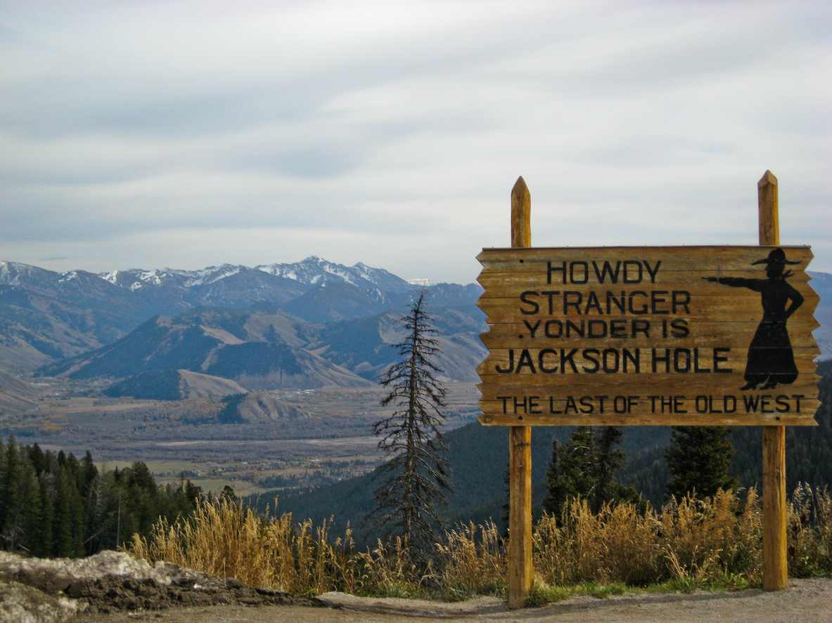 a rustic sign that reads "howdy stranger yonder is jackson hole, the last of the old west"