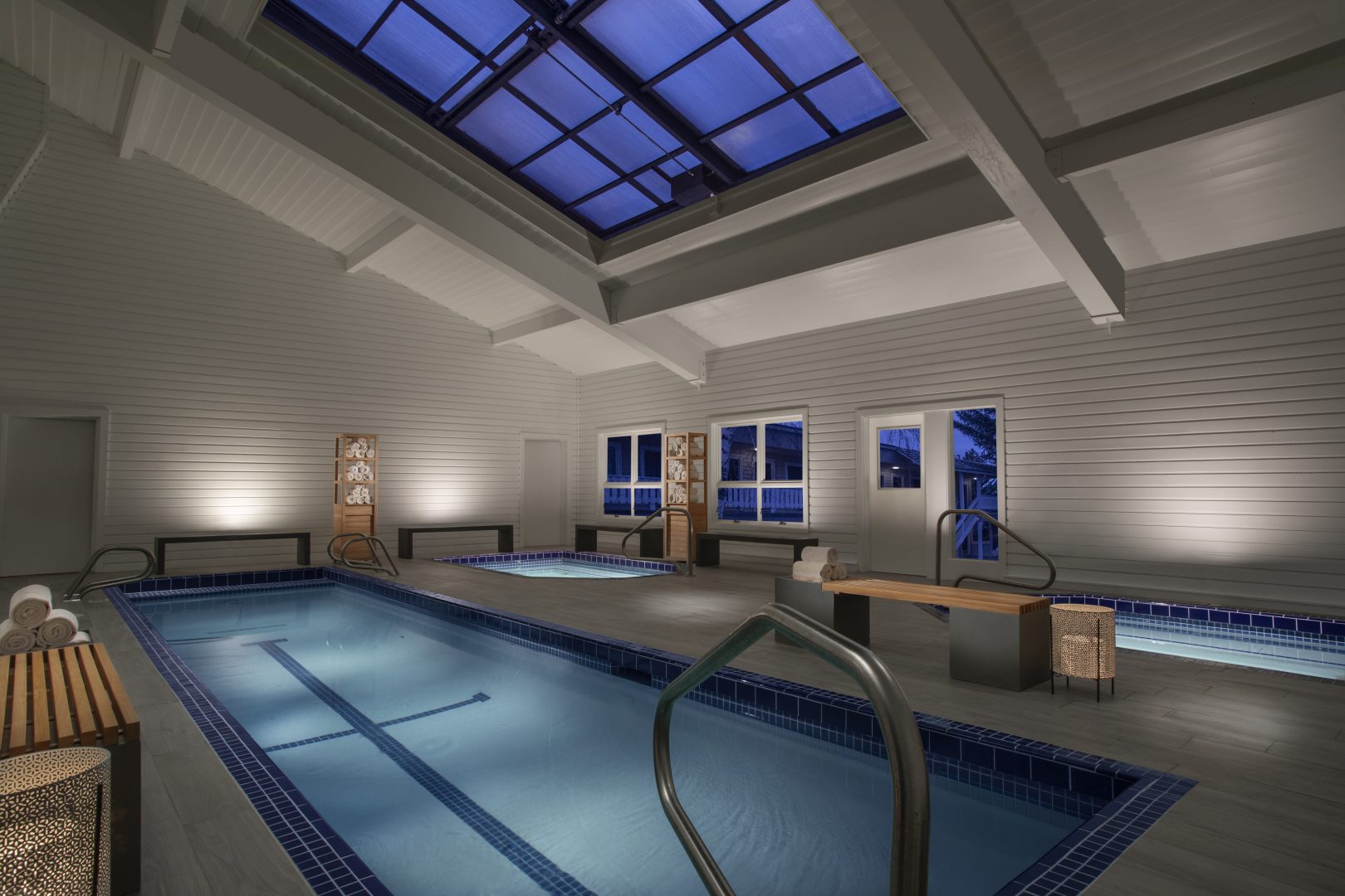 luxurious indoor pool and hot tub facilities with a skylight